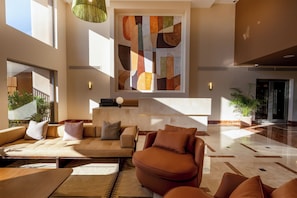 A spacious lobby with a modern sofa, a coffee table, and a large abstract painting on the wall.