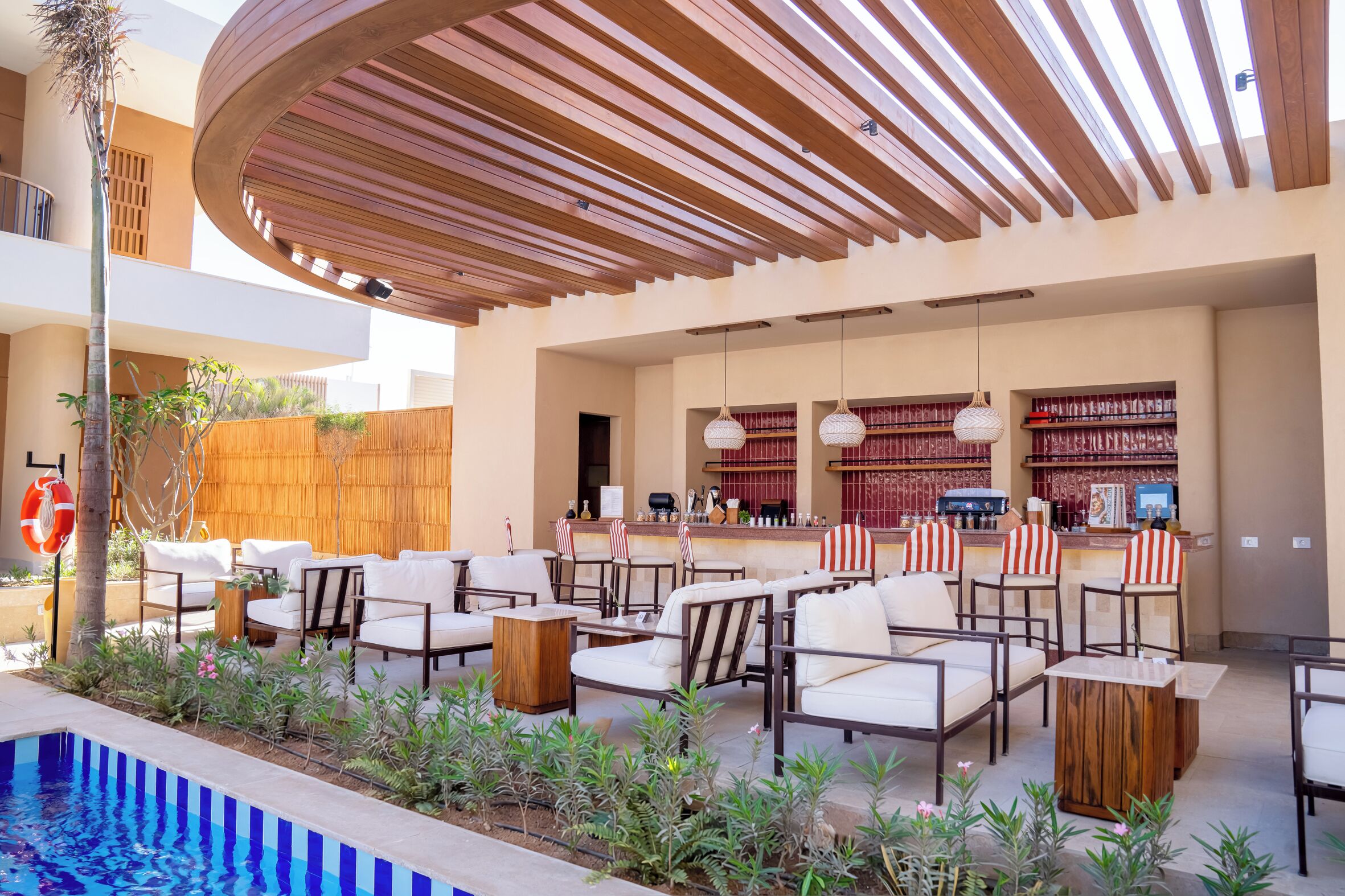 An outdoor seating area with lounge chairs and a pool.