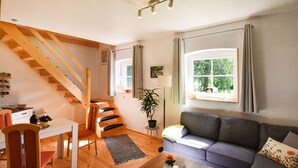 A cozy living room with a staircase, a sofa, a dining table, and a potted plant. - Gorgeous home in Dobbertin with WiFi (Dobbertin)