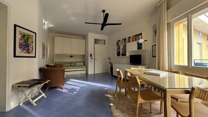 A room with a bed, a desk, a chair, a bookshelf, and a window. - Great flat with two terraces and parking (Bibione)
