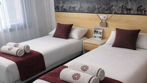 A hotel room with two beds, a headboard with a mural, and a window with sheer curtains. - EL MENSARIO (Campisábalos)