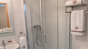 A modern bathroom with a glass-enclosed shower, a white sink, and a toilet. - EL MENSARIO (Campisábalos)