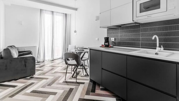 Eine moderne Küche mit Mikrowelle, Kaffeemaschine und einem Essbereich mit Tisch und Stühlen.