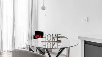 Ein modernes Zimmer mit Glastisch, Stuhl, Pendelleuchte und einem Schild mit der Aufschrift 'NETFLIX HOME'.
