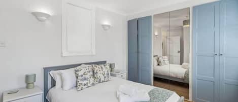 2 habitaciones, escritorio y tabla de planchar con plancha