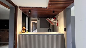 A room with a sloped ceiling, a radiator, and a ceiling fan. - Hotel NR INN (Ahmedabad)