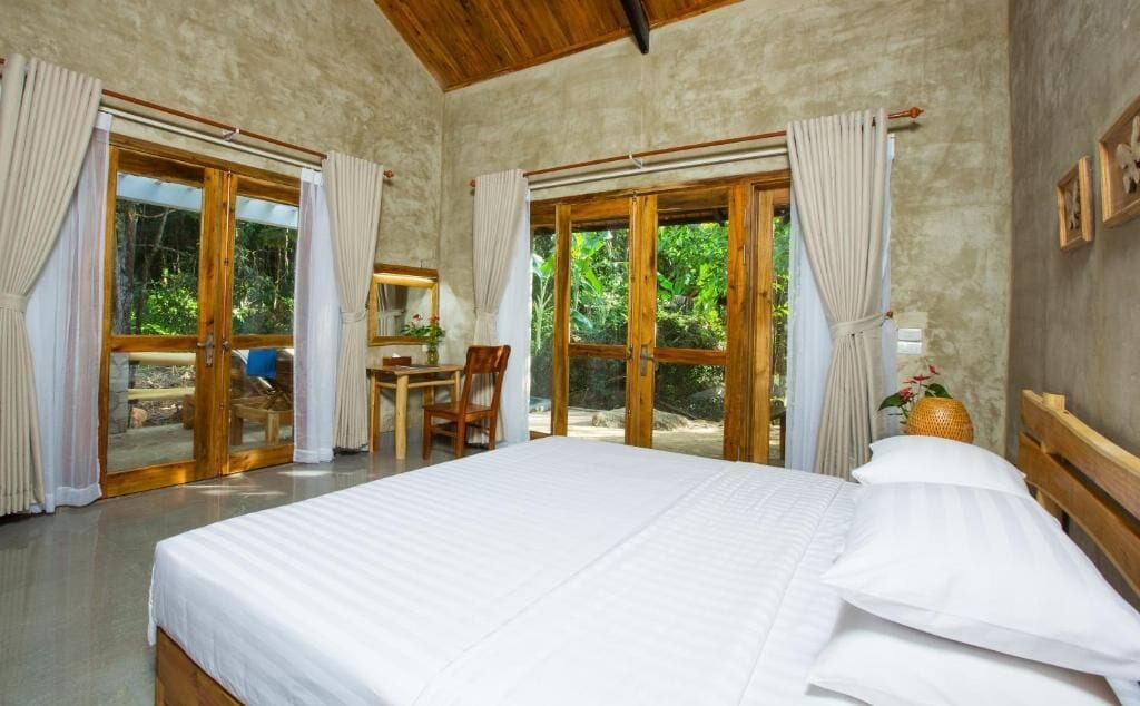 Une chambre à coucher avec un grand lit, une tête de lit en bois et un bureau avec une chaise.