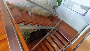 A wooden staircase with a glass railing, a stone wall, and a potted plant. - Sunrise Escape with Pool by Portugal Active (Viana do Castelo)
