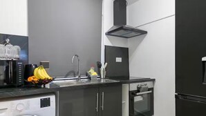 A modern kitchen with a washing machine, a sink, and a built-in oven.
