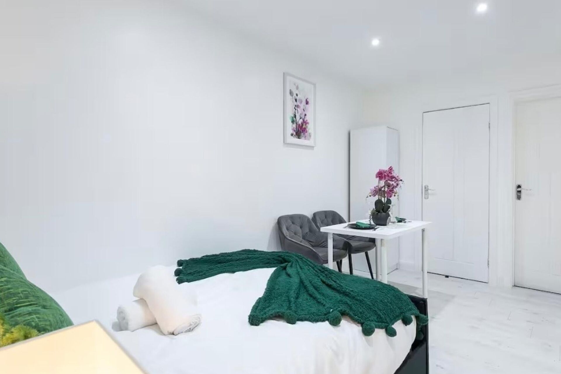 A modern bedroom with a bed, a desk, and a chair.