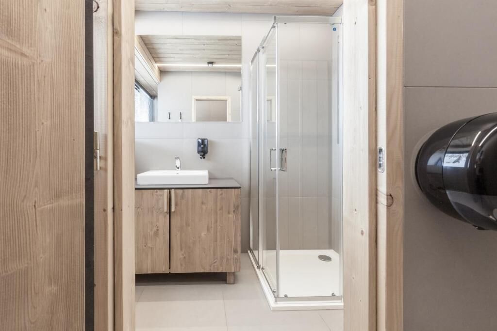 Un baño moderno con ducha, lavamanos y espejo.