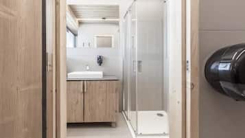 Un baño moderno con ducha, lavamanos y espejo.