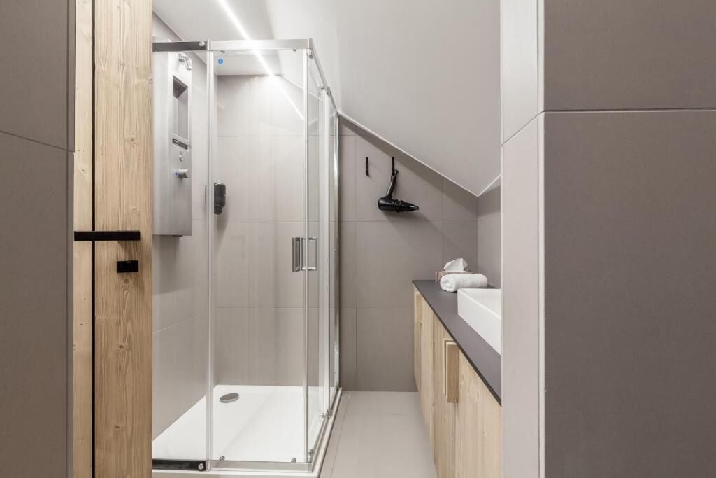 Une salle de bain moderne avec une douche à parois de verre, des toilettes et un espace lavabo.