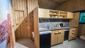 A compact kitchen with wooden cabinets, a sink, and a dishwasher. - Chata Zázvor (HORNÁ LEHOTA)