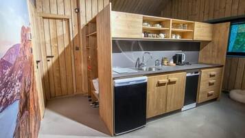 A compact kitchen with wooden cabinets, a sink, and a dishwasher.