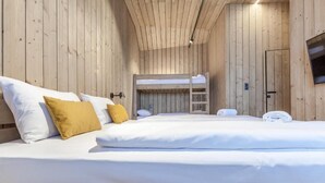 A wooden cabin-style room with bunk beds and a television. - Chata Zázvor (HORNÁ LEHOTA)