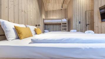 A wooden cabin-style room with bunk beds and a television.