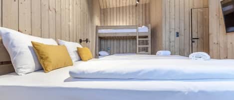 A wooden cabin-style room with bunk beds and a television.