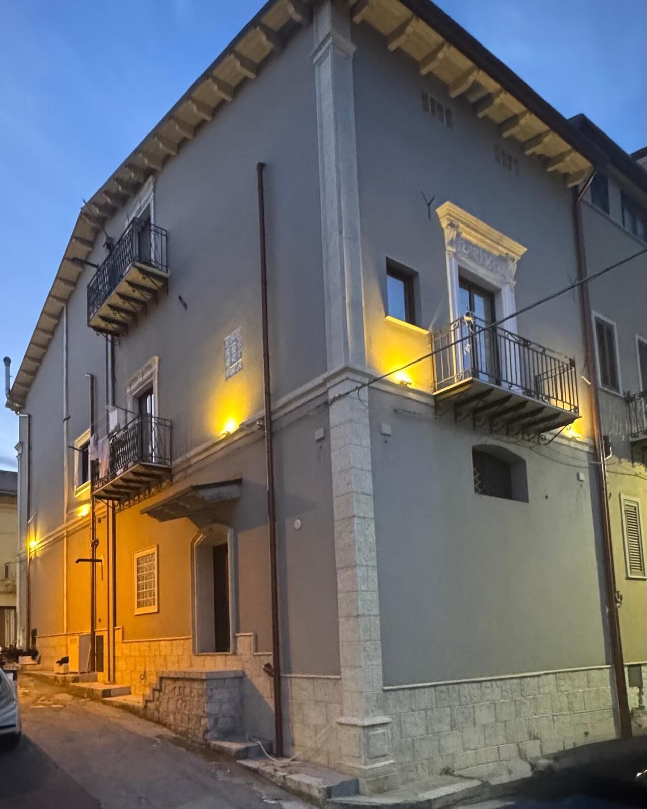 A two-story building with a balcony, a door, and a small window.