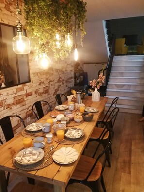 A dining area with a brick wall, hanging plants, and a staircase. - Spacious 225 m² family home for 8 people with a pool (3 bathrooms) (Bornos)
