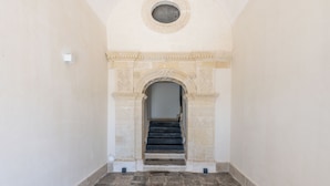Una escalera con un arco decorativo que lleva a una plataforma.