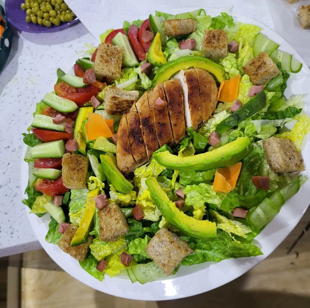 Ensalada de hojas verdes con diversos vegetales y crutones.