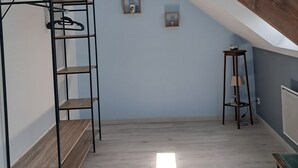 A room with a sloped ceiling, a bunk bed, a small table, and a radiator. - Detached house just 5 minutes from Terrasson Lavilledieu—perfect for exploring the region! (Brignac-la-Plaine)