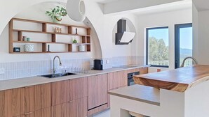 Eine moderne Küche mit Holzschränken, einer eingebauten Spüle und einem großen Fenster mit Blick.