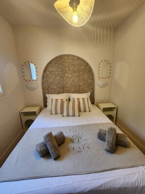 A neatly made bed with a headboard, two bedside tables, and a wall-mounted mirror. - Villa Elaïa - Panoramic view of the sea and the maquis, with a pool in Porto-Vecchio (Porto-Vecchio)