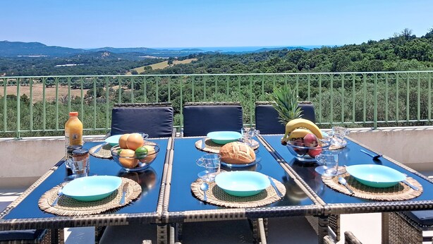 Ein Tisch ist für eine Mahlzeit gedeckt, mit Blick auf die Landschaft.