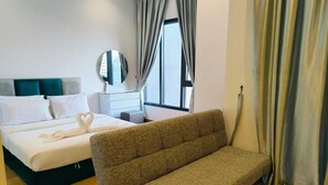 Une chambre à coucher avec un lit, un canapé, un miroir et une fenêtre avec des rideaux.