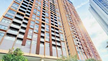 Un edificio alto con varios balcones y una piscina al frente.