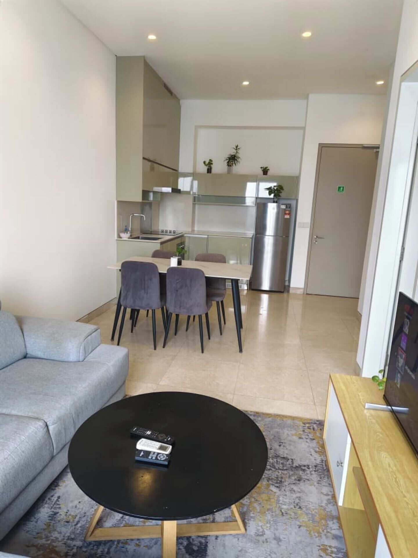 Una sala moderna con un sofá, una mesa de centro y un mueble para televisión.