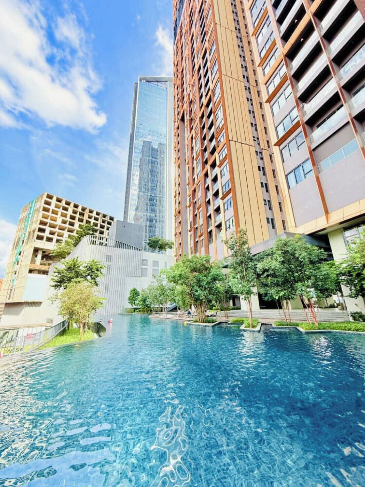 A swimming pool surrounded by high-rise buildings with a clear sky.