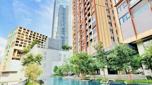 A swimming pool surrounded by high-rise buildings with a clear sky.