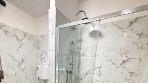 Un baño moderno con ducha de vidrio, inodoro y bidé.