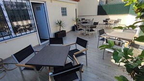 An outdoor patio with tables and chairs, a door, and a small plant. - Lisbon Airport GuestHouse Gal - Suite w/ Wc (Lisboa)