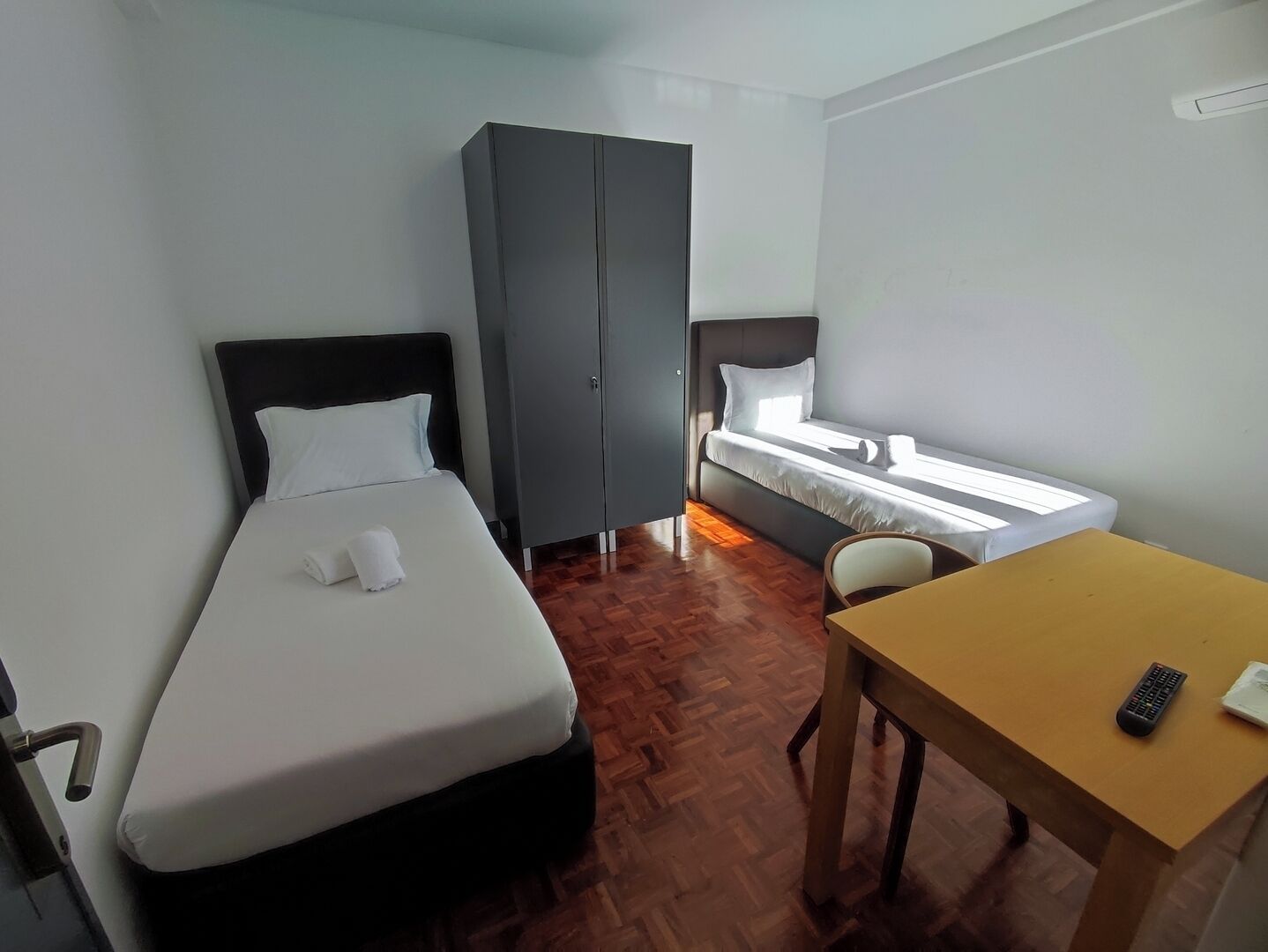 Una camera d'albergo con un letto, un armadio, una scrivania e una finestra.