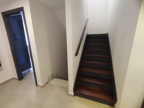 A staircase with a handrail, carpeted floor, and a door leading to another room. - Lisbon Airport GuestHouse Gal – Twin Bedroom (Lisbon)