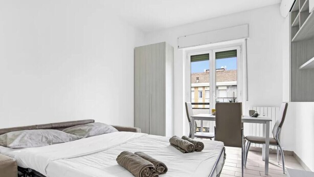 Una habitación de hotel con una cama, una mesita y una silla.