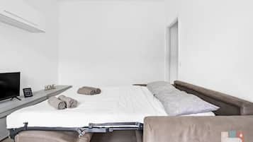 Tabla de planchar con plancha, internet y ropa de cama