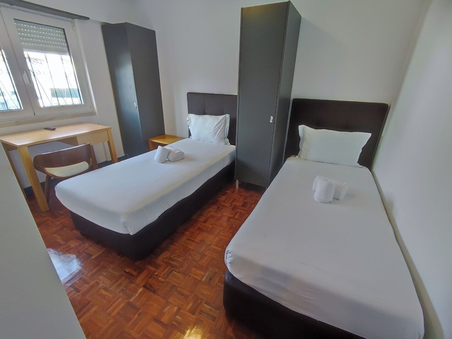 Una habitación de hotel con dos camas, un escritorio y una silla.