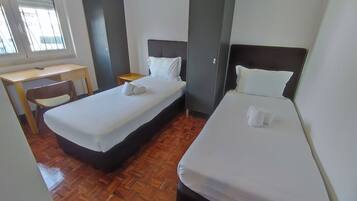 Una habitación de hotel con dos camas, un escritorio y una silla.