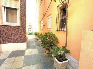 A narrow alleyway with potted plants and a building with a tiled floor. - Cozy one-bedr. apartment in Costa da Caparica (Costa da Caparica)
