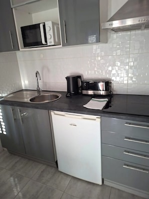 A kitchen with a sink, a microwave, a coffee maker, and a dishwasher. - Algarve, T1 Armação de Pêra near the Beach (Armação de Pêra)