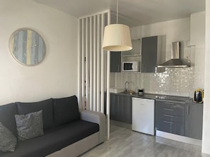 A modern kitchen with a microwave, stove, and dishwasher. - Algarve, T1 Armação de Pêra near the Beach (Armação de Pêra)