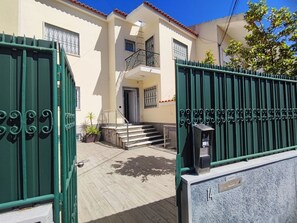 A building with a gated entrance, a staircase leading to a second floor, and a mailbox. - Lisbon Airport GuestHouse Gal – Twin Bedroom (Lisbon)