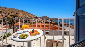 Ein Balkon mit Tisch für Zwei, einem Buch, einer Schale Weintrauben und zwei Gläser Orangensaft.