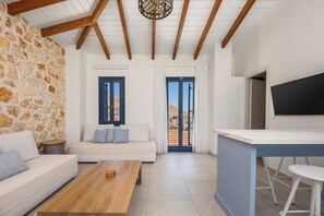 A living room with a stone wall, a sofa, a wooden coffee table, and a TV on a stand.