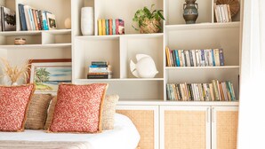A bedroom with a bed, pillows, a bookshelf, and a decorative vase. - Luxury Beachfront Villa • Private Pool, Beach, AC, Calm Lagoon (La Preneuse)